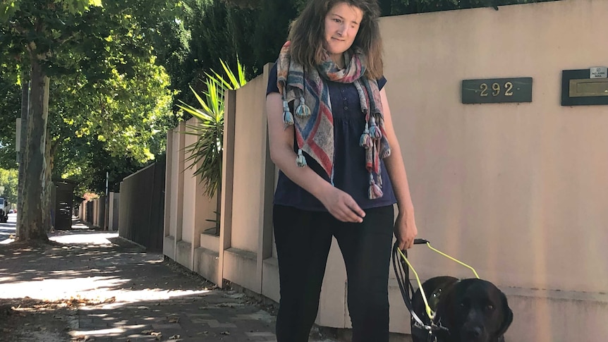 Ellen Fraser-Barbour walks along the street with her guide dog.