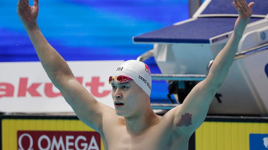 Chinese swimmer Sun Yang lifts up both arms in celebration after winning a race in 2019.