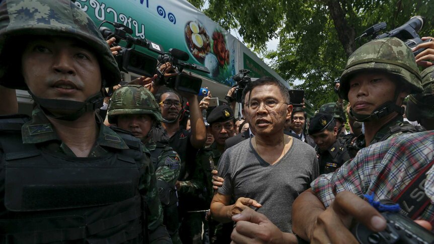 Former Thai commerce minister Watana Muangsook escroted by military personnel.