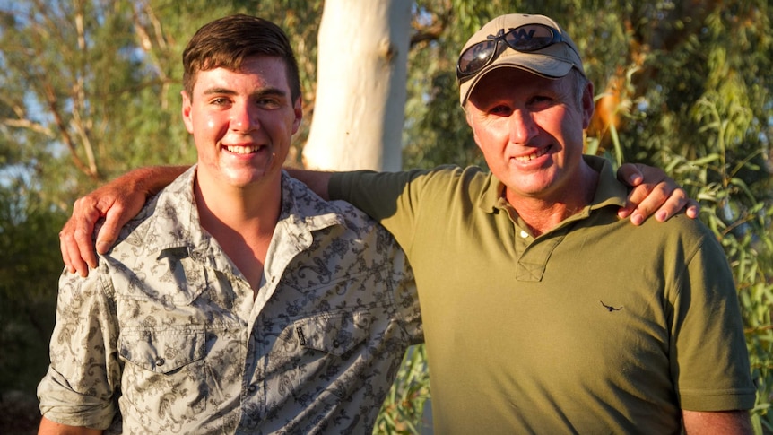 Father and son with arms around eachother's shoulders