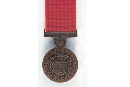 A medal on a red strip of material.