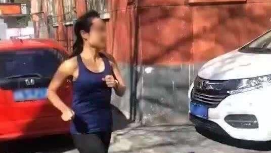 A woman with her face blurred is seen jogging on the streets.