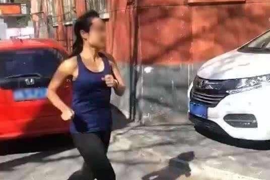 A woman with her face blurred is seen jogging on the streets.