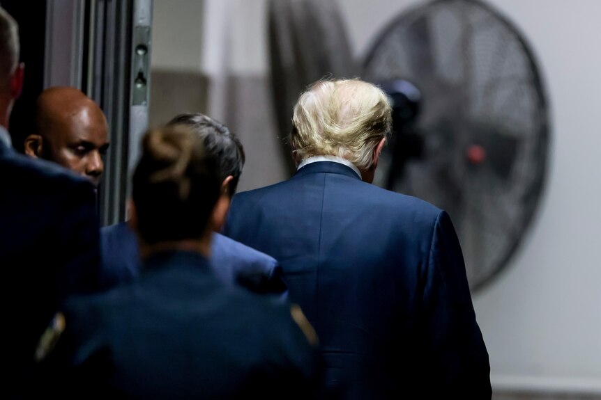 The back of Donald Trump as he leaves court