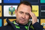 Ricky Stuart stares languidly into the middle distance while rubbing his temple with his left hand during a press conference.