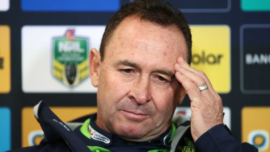 Ricky Stuart stares languidly into the middle distance while rubbing his temple with his left hand during a press conference.