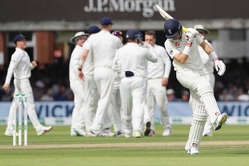 A cricketer kicks at the turf in anger after his teammate is run out and the other team celebrates.