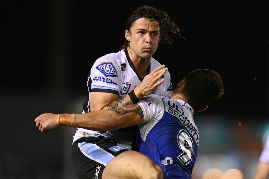 A Cronulla NRL player is tackled by a Canterbury opponent.