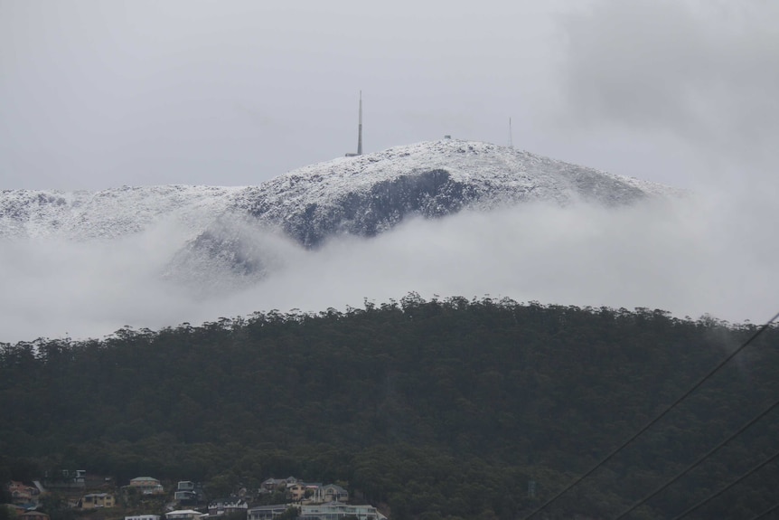 Snow covers the peak of Mt Wellington above the cliff known as the Organ Pipes. July 31, 2014