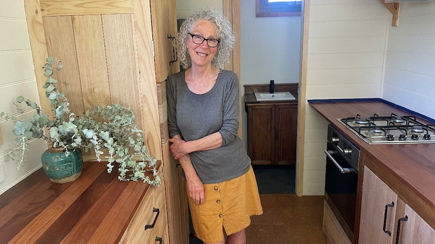 woman standing in tiny house kitchen
