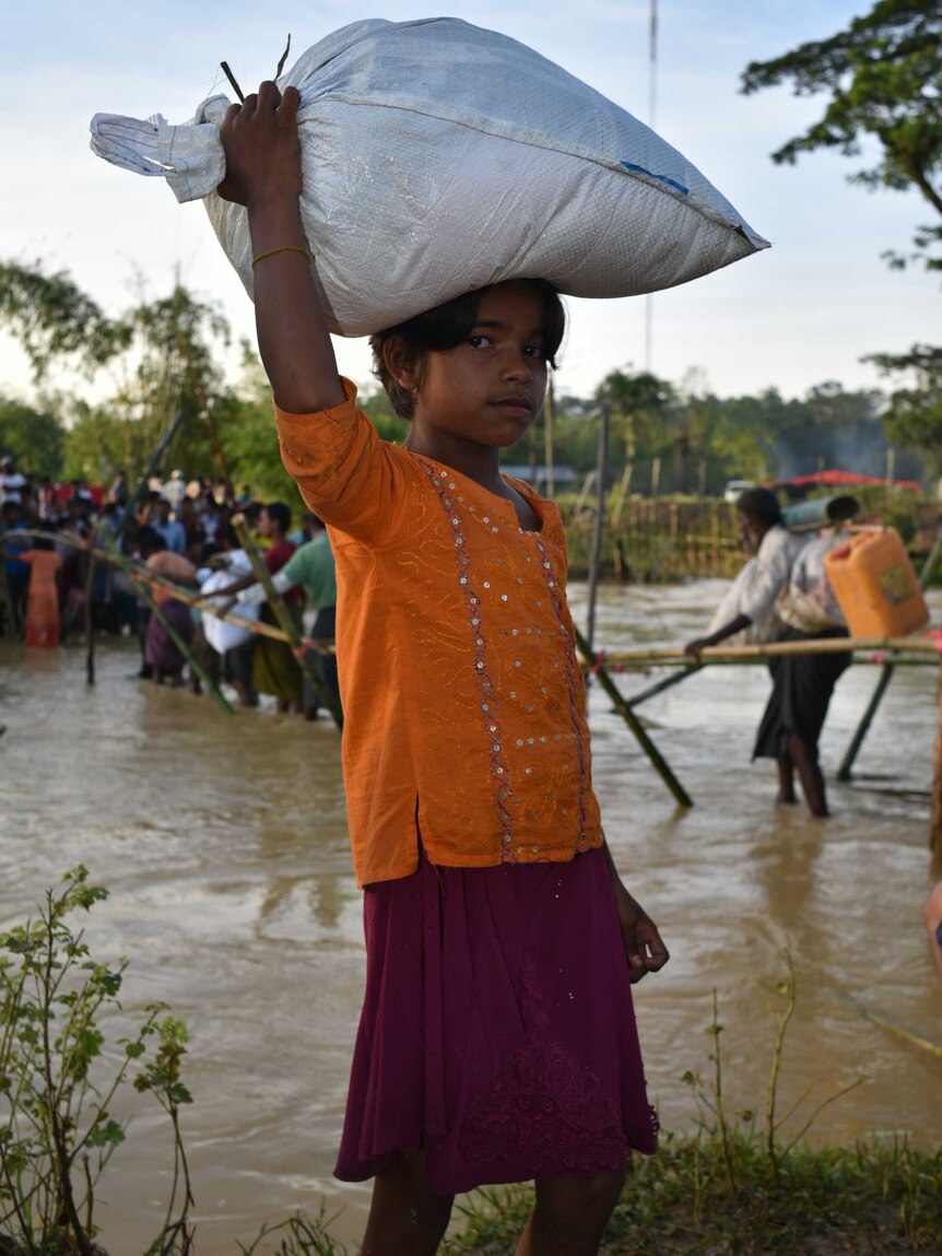 Shajeda carries a 20 kilogram bag of rice on her head.