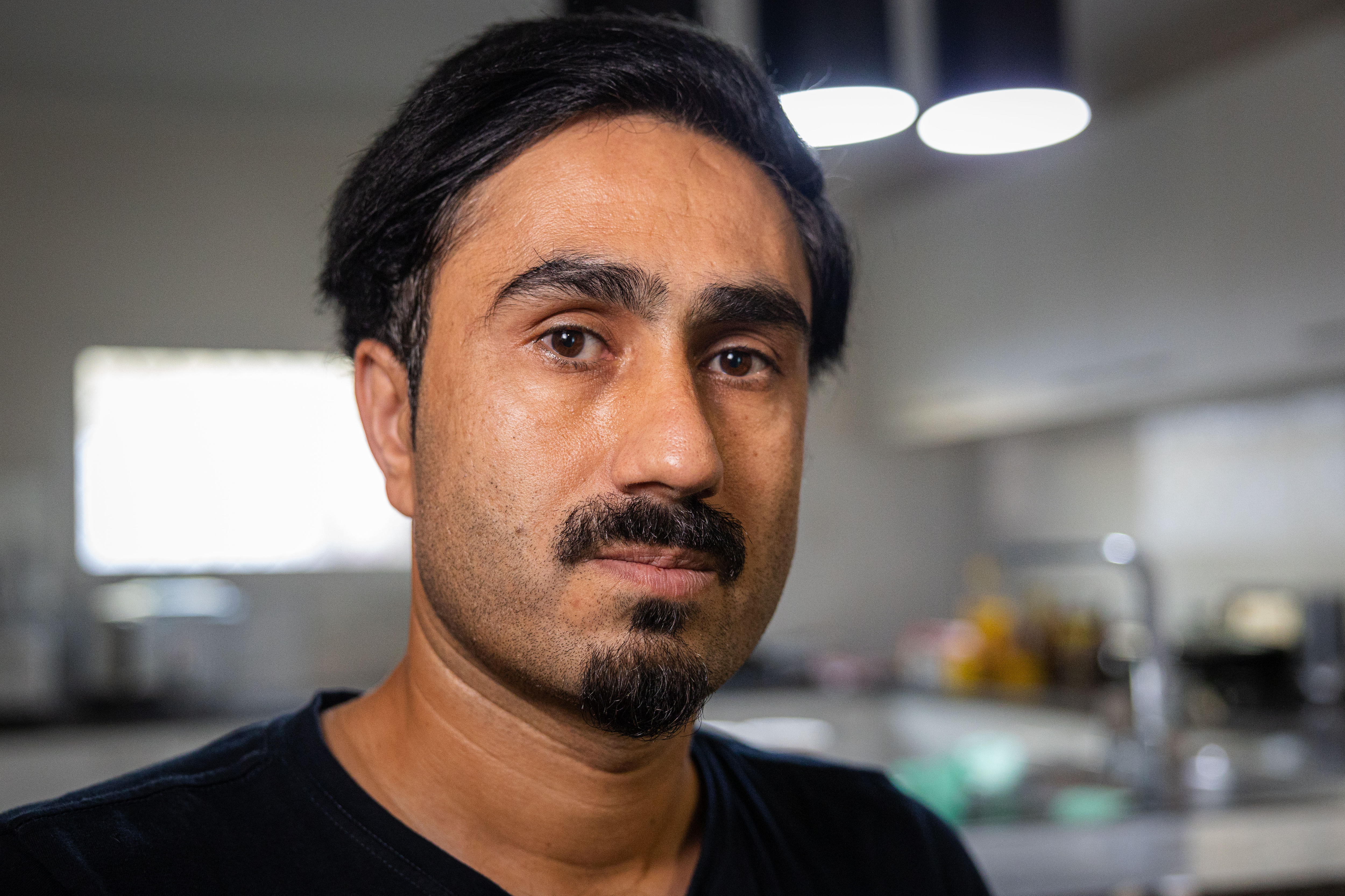 Close up of Shah. He has black hair, a moustache and goatee.