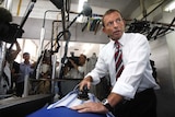 Opposition Leader Tony Abbott irons a shirt at a dry cleaners