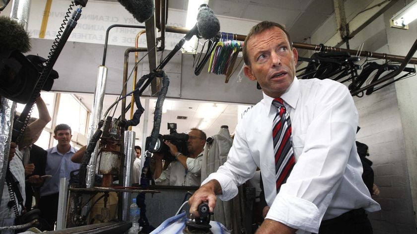 Opposition Leader Tony Abbott irons a shirt at a dry cleaners