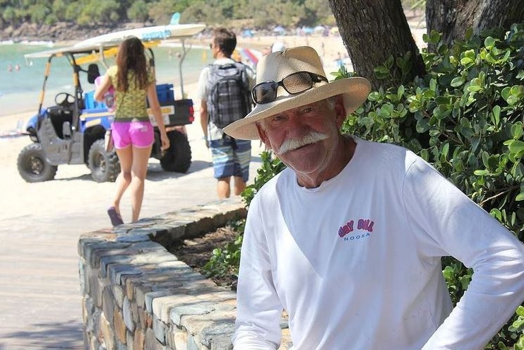Grey-haired man with moustache on beachside boardwalk