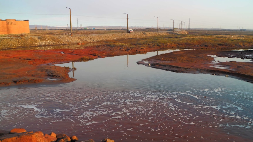 The oil spill outside Norilsk, the earth is red due to to the spill and the water also has a reddish tone.