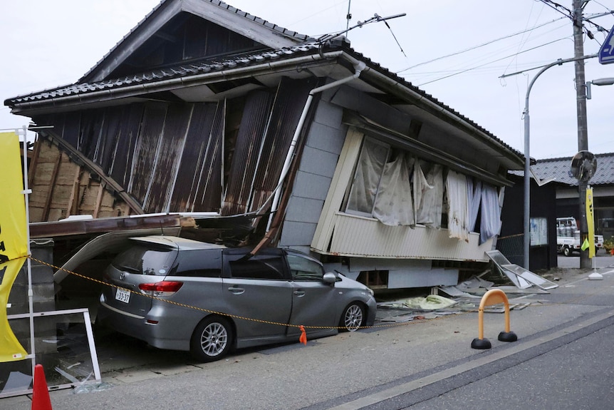 A car is seen crushed by a collapsed house after a strong earthquake in Suzu city, Ishikawa prefecture, northern Japan, 