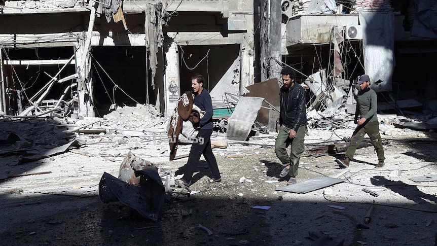 Citizens inspect the ruins of a building after a devastating airstrike.