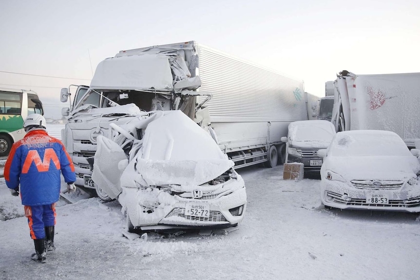 Several crashed cars and a truck covered in snow.