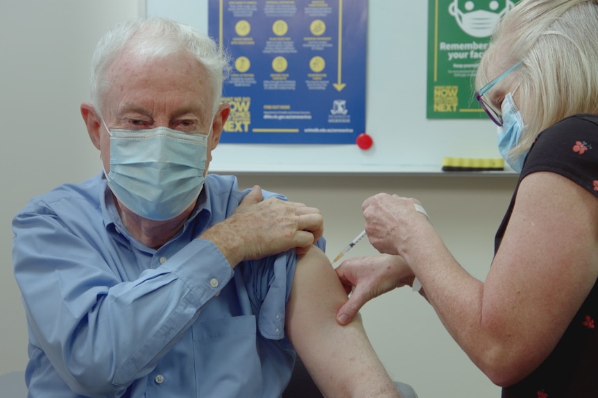 Nurse administers a vaccine in Peter Doherty's arm.