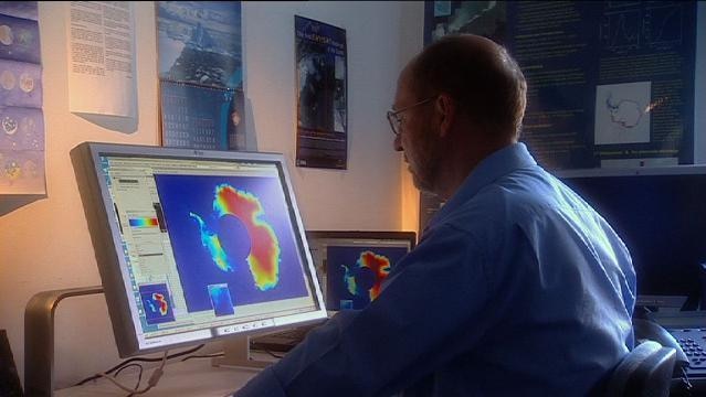 Man looks at computer image of Antarctica on computer