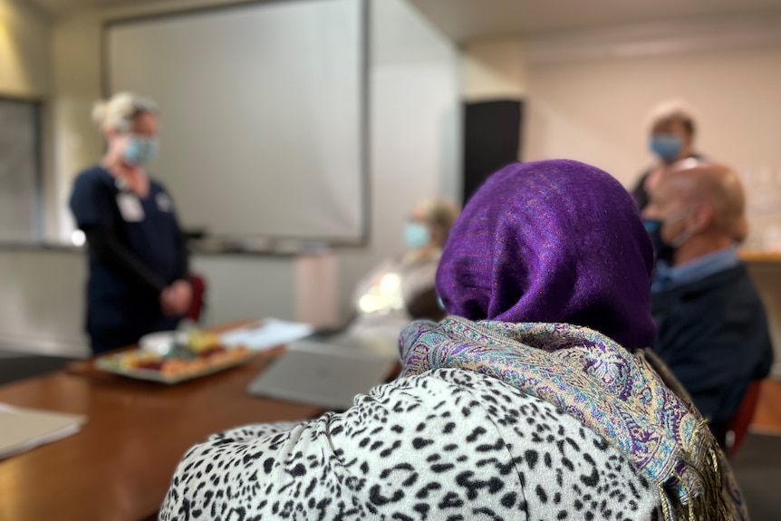 Woman sits listening to a session