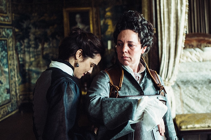 Colour still of Rachel Weisz and Olivia Colman having an intimate moment in 2018 film The Favourite.