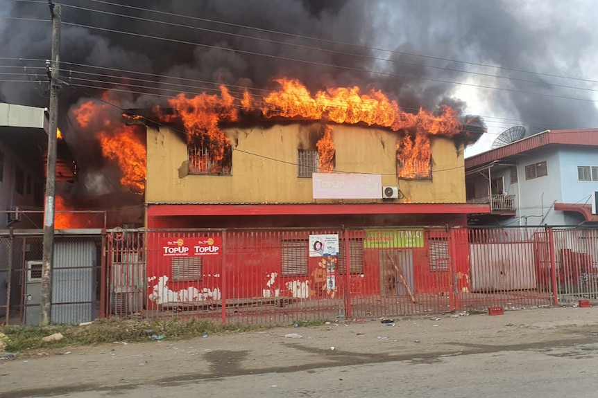 A building stands alight in Honiara amid protests