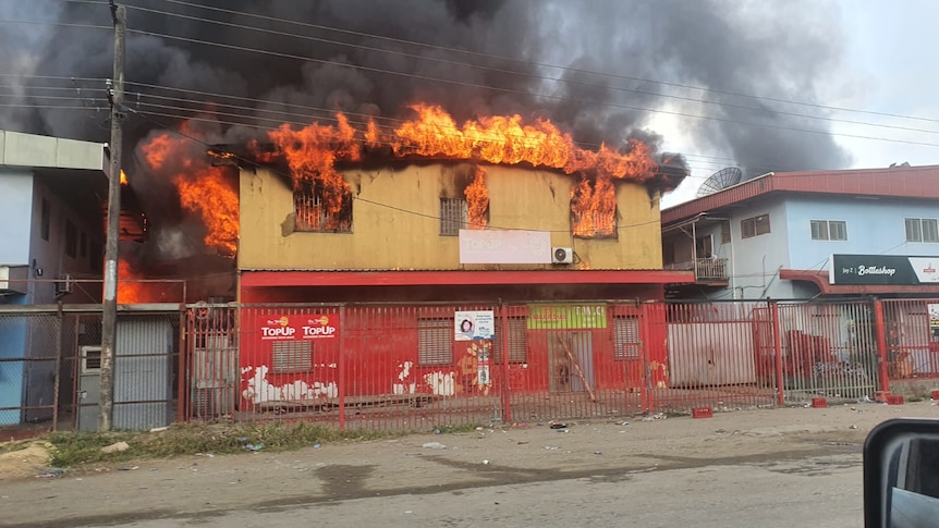 A building stands alight in Honiara amid protests