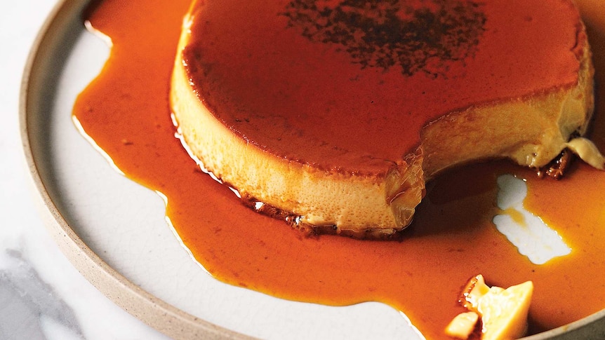 Bird's eye photo of a creme caramel dessert with vanilla seeds on top.