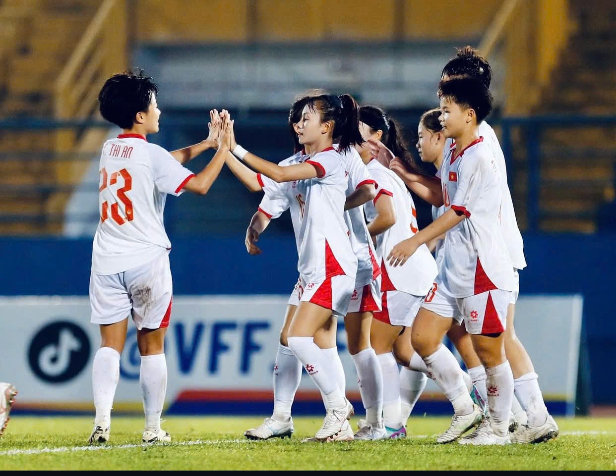 Jogadoras da seleção feminina de futebol do Vietnã cumprimentam e comemoram