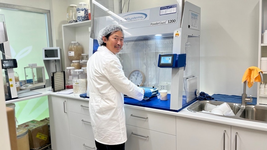 Man in lab coat and cap in a laboratory.