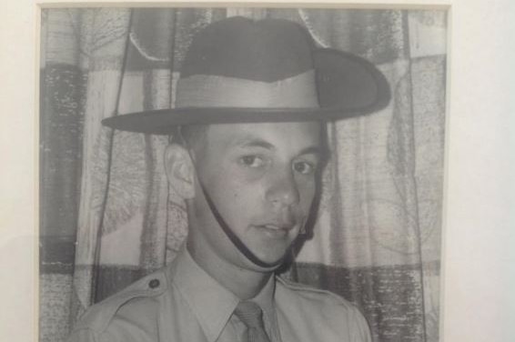 A black and white photo of a young soldier in uniform.