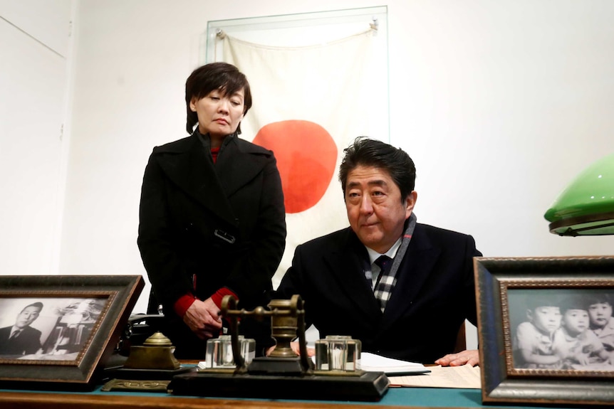 A man and a woman behind a desk.