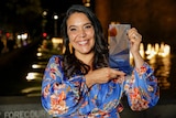 A woman smiling at the camera holding an award