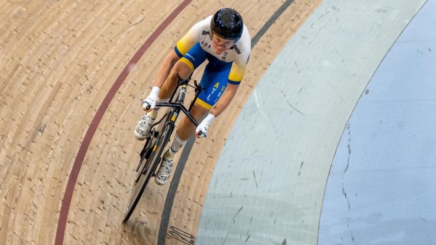 A shot looking down at a female cyclist on a velodrome.  