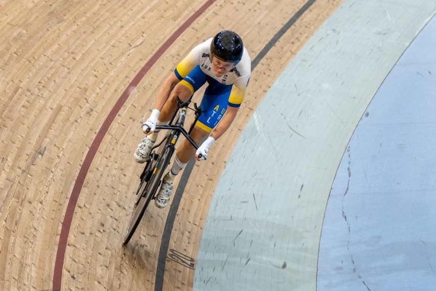 A shot looking down at a female cyclist on a velodrome.  