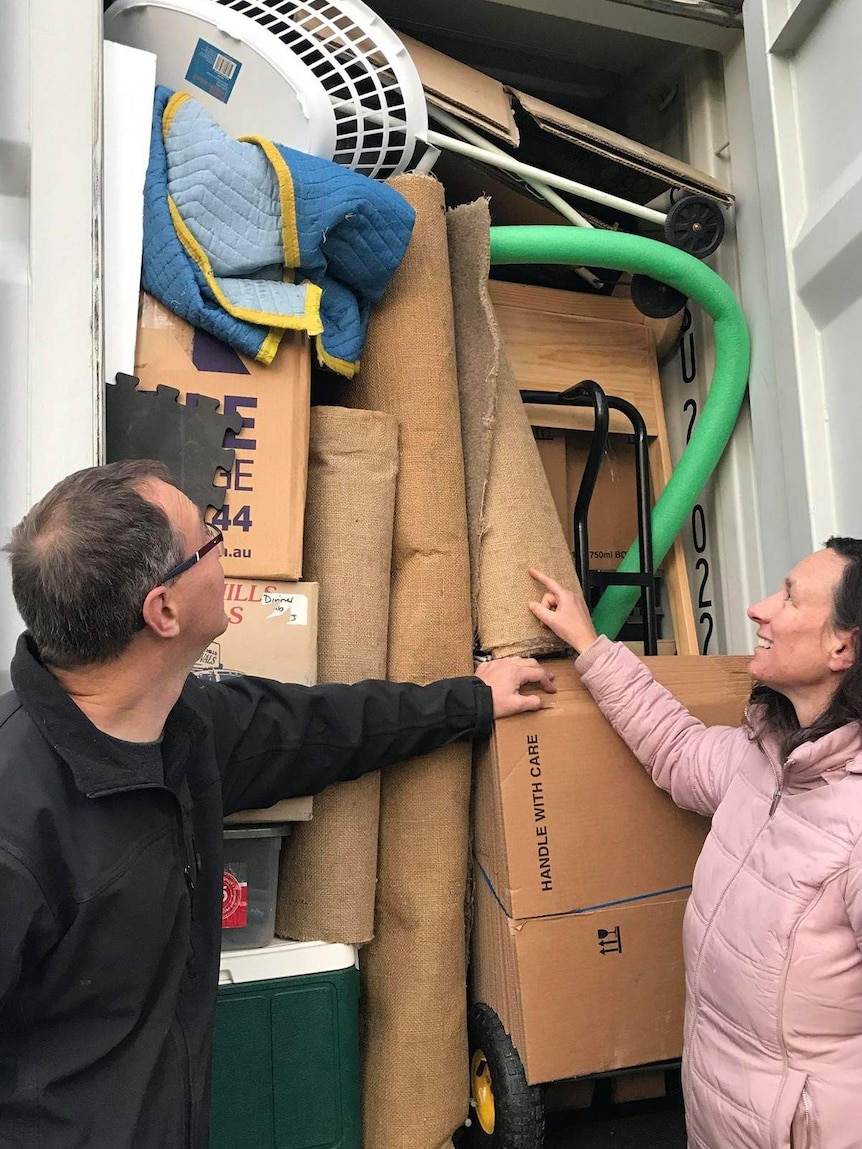 Couple inspects their container of furniture