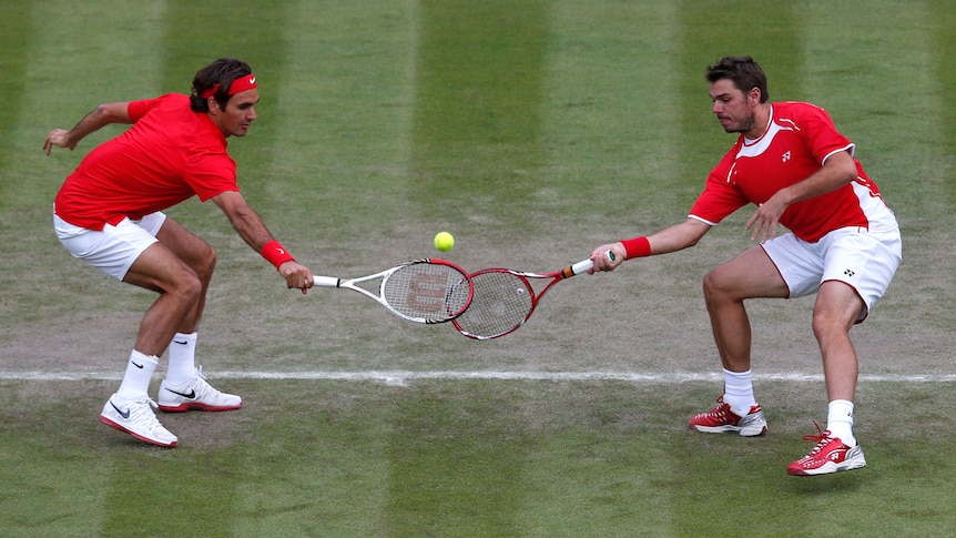 Sharing the load ... Switzerland's Roger Federer and Stanislas Wawrinka muddle up a return.