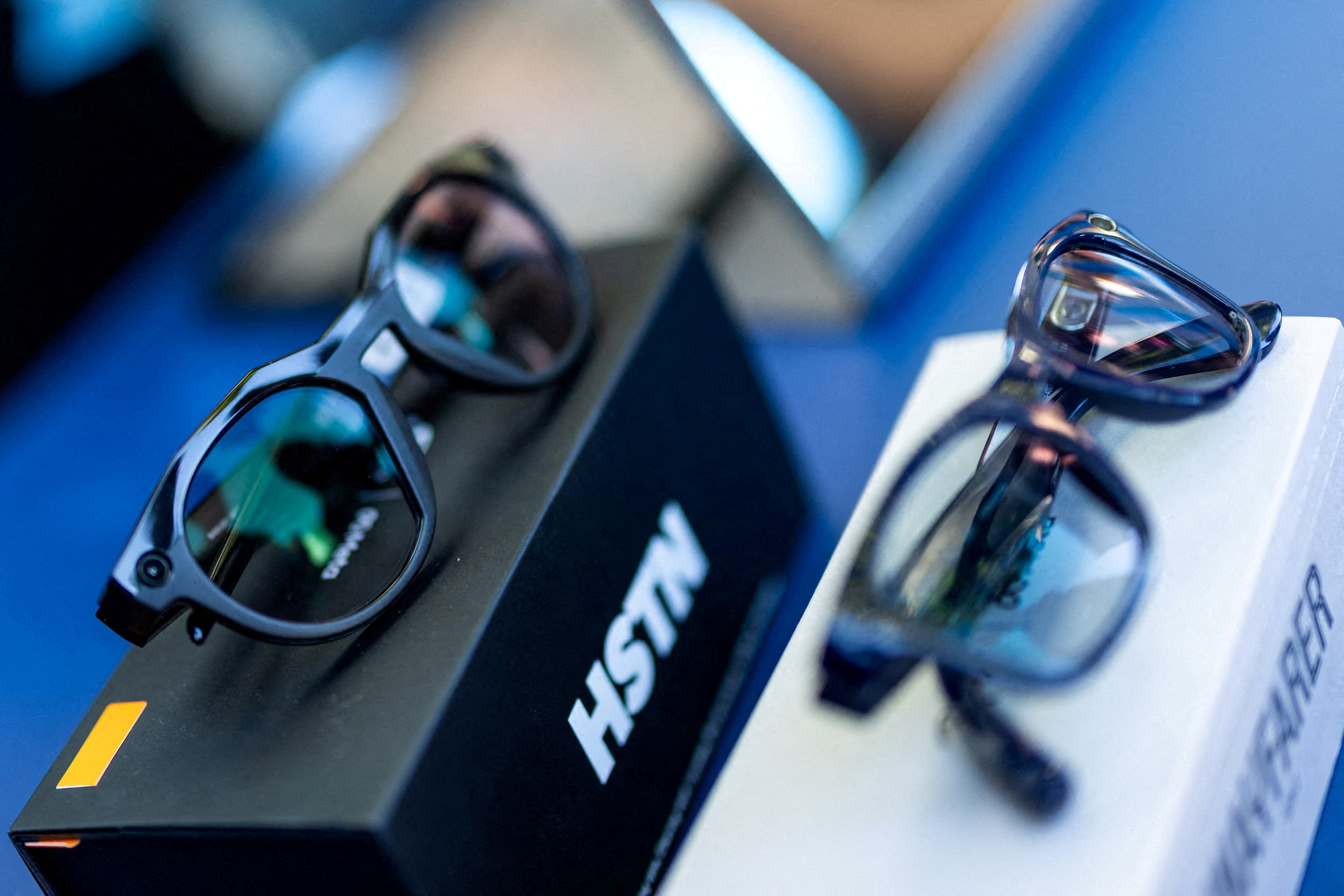 Two pairs of smart glasses on display at a public event.