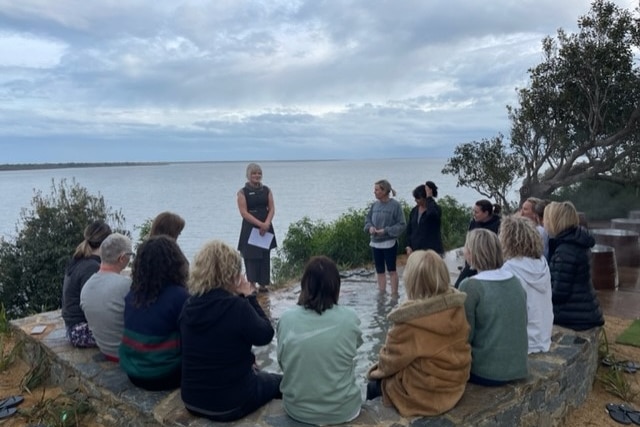 A circle of women listening to an instructor 