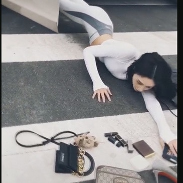A Chinese influencer posed as she fell out of a car on the crosswalk with her luxury goods scattered on the floor.