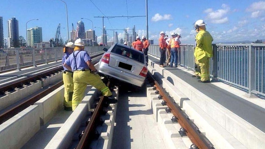 Car drives down the Gold Coast Light Rail line at Southport on March 13.