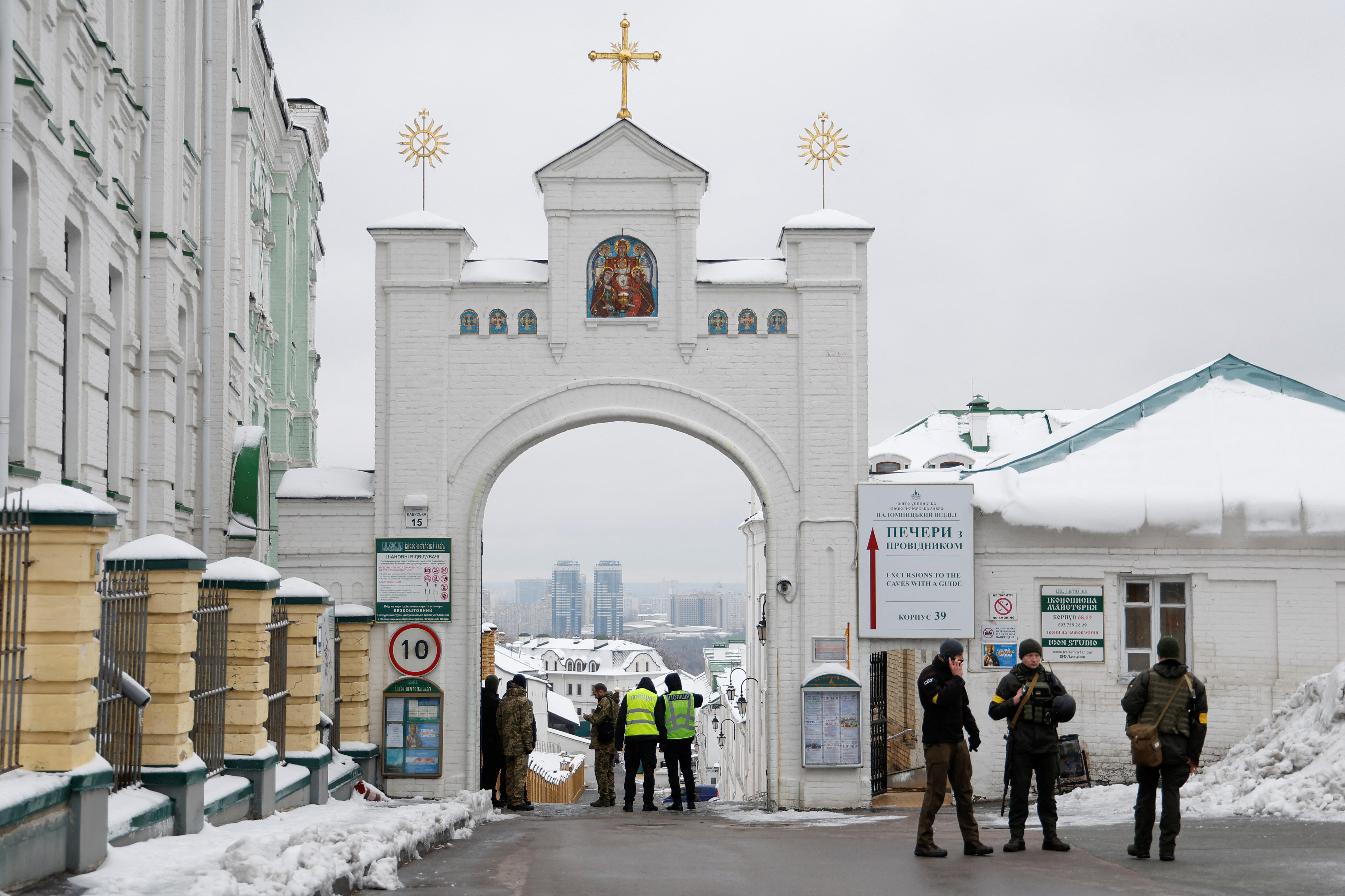 Ukrainian officers stand next to a gate.
