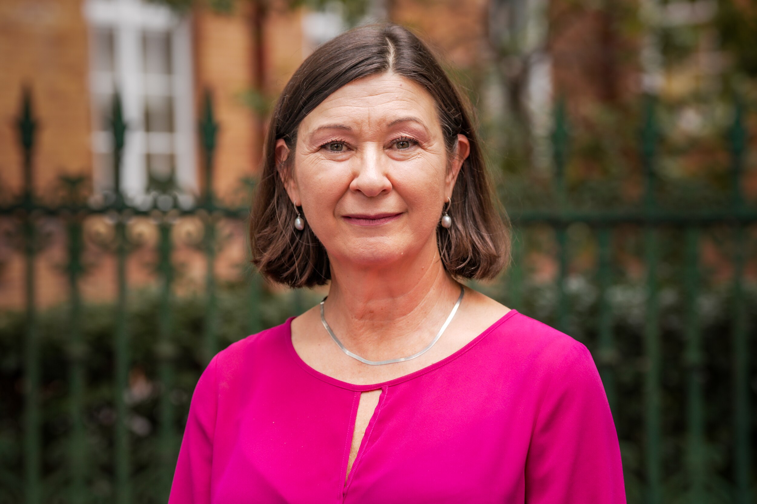 Woman with short brown hair and pink shirt.