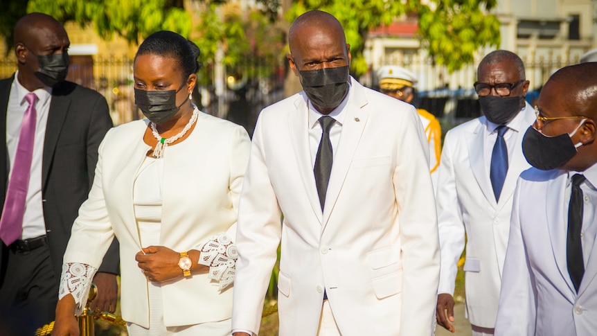 Jovenel Moise and Martine Moise in all-white outfits and black face masks 