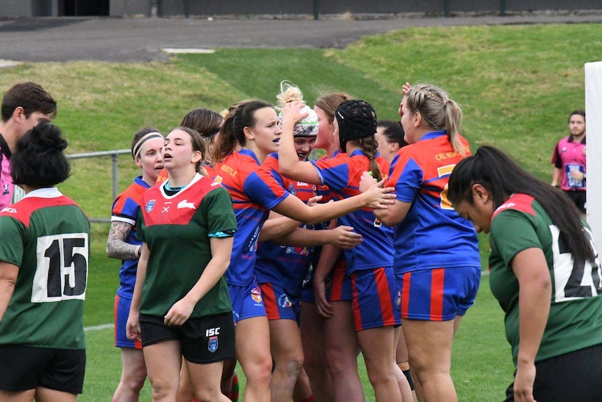 Newcastle Rugby League players celebrate a try.