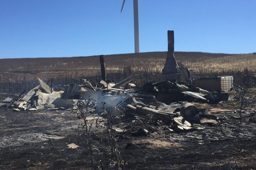 The smouldering remains of a home, in a burnt out paddock.