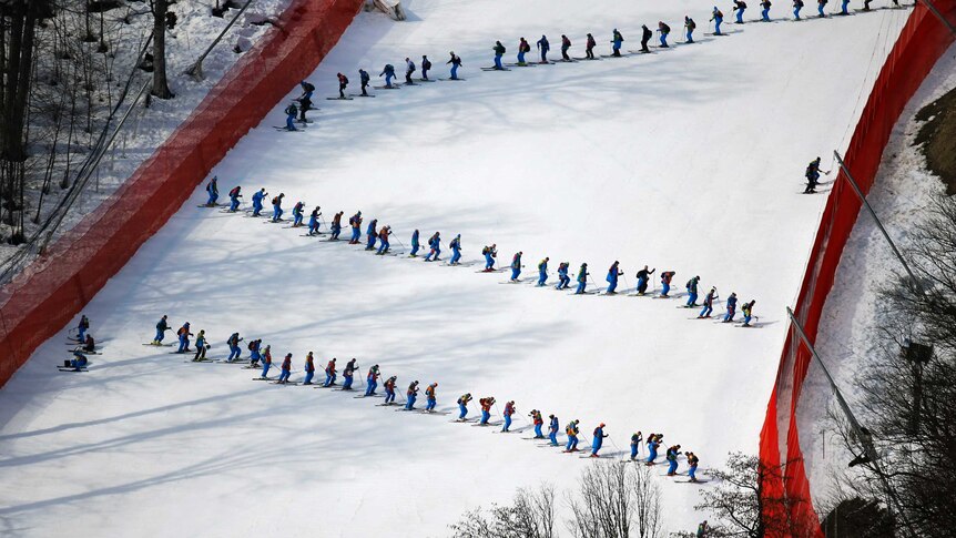 Course slippers prepare the alpine ski course at the Sochi Winter Olympics.