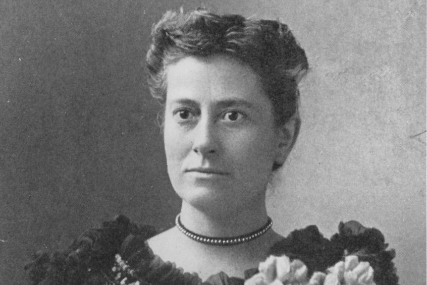 A black and white portrait of Williamina Fleming in an ornate frilled black dress